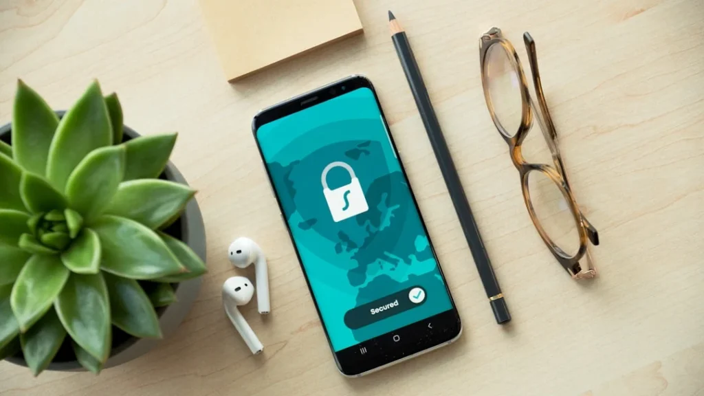Telefon biztonságos VPN kapcsolattal, asztal rendezett kiegészítőkkel.